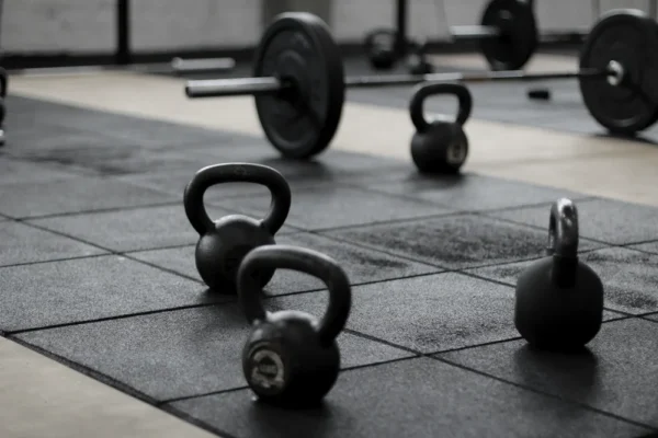 Kettlebells et barres sur le sol caoutchouc d'une salle