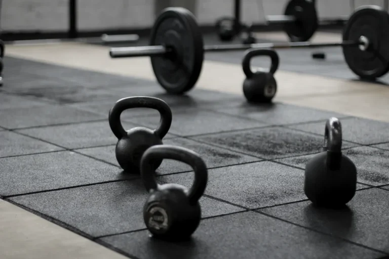 Kettlebells et barres sur le sol caoutchouc d'une salle